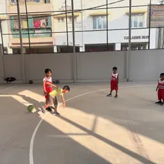 A young player practices a wheelbarrow race, a fun drill to build strength and teamwork in our basketball classes.