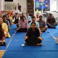 A wide view of a corporate yoga class in progress. We can adapt to any office environment, from a large conference room to a small break area, to create a space for relaxation and rejuvenation.