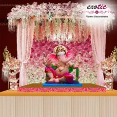A truly grand Ganpati mandap featuring a full wall of pink flowers, a delicate canopy with hanging floral strings, and soft draping. This luxurious design creates a heavenly abode for Bappa, perfect for large-scale celebrations.