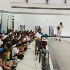 Our head coach addresses a hall full of attentive students. These group sessions are vital for discussing strategy, sharing lessons from competitions, and reinforcing our club's values.