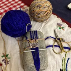 Here you can see the weaving in progress, directly on the surface of the stone. The stone itself becomes the loom, and the process of wrapping and weaving the yarn is a slow, deliberate, and calming activity.