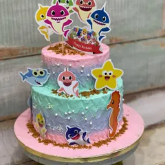 This two-tiered Baby Shark cake was so much fun to make for a little one's birthday. The colorful buttercream and cute character toppers brought the underwater theme to life.