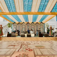 The stage for the live band, set against a backdrop of traditional Rajasthani architectural motifs. The custom-printed dance floor features designs inspired by local flora and fauna.