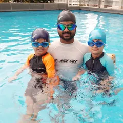 I believe in a hands-on approach, which is why I am always in the pool with my students. This photo is from a private lesson at a client's residential pool, where I am coaching two young siblings together.