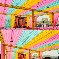My decor services are not just for weddings. This is a large-scale tent and seating arrangement I managed for a 'Guruji' event, using bright drapes and clean white chair covers to create a serene and organized space.