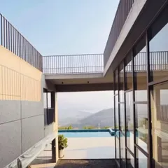 A view from a lakeside home in Pawna, where the architecture is shaped by light and the natural breeze. The design frames the stunning scenery, with an infinity pool that appears to merge with the distant lake and mountains.