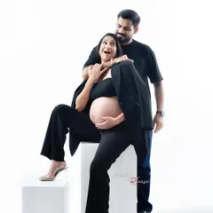 A fun and candid moment between a couple during their modern studio shoot. Dressed in matching black outfits, their playful interaction makes for a memorable and authentic portrait.