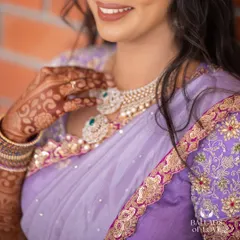 A close-up on the intricate henna and the fine embroidery of the lilac bridal blouse, highlighting the textures and details.