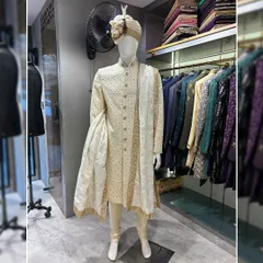 A classic groom's look never goes out of style. This is a beautifully crafted off-white sherwani with subtle self-embroidery, paired with a matching pagri (turban) and stole. It’s a testament to timeless elegance for the main wedding ceremony.
