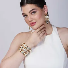 A close-up shot focusing on a model's elegant pose, showcasing a statement cuff bracelet and matching earrings, ideal for modern jewellery e-commerce listings.