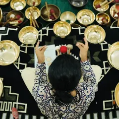An overhead view of a student surrounded by a set of chakra-tuned singing bowls.