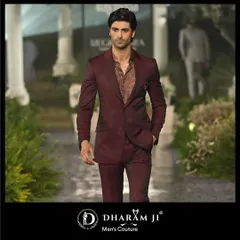 A model showcasing a deep maroon suit on the runway. The slim fit and rich color make it a versatile choice for a wedding guest or for a groom's reception look.