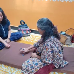 Two participants enjoying a game of Five Stones, exploring how traditional play can become a tool for experiential learning.
