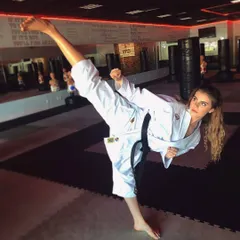 A female black belt student executing a flawless high kick in our dojo. We train our students to the highest levels of proficiency in Karate and Taekwondo.