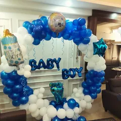 A 'Welcome Baby Boy' decoration with a blue and white balloon ring. The setup includes 'BABY BOY' foil letters and a baby bottle foil balloon.