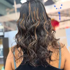A view of the caramel highlights from inside the salon. The color looks rich and glossy, proving that you can have beautiful color without compromising on hair health.