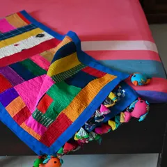 The corner of the quilt is turned over to show the playful details and the sheer variety of fabrics used. Creating a fully upcycled product like this brings me immense satisfaction.