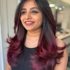 A stunning transformation to a bold magenta balayage. The soft layers and feathered ends make the color pop.
