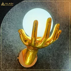 A unique and artistic wall sconce designed as a golden hand holding a glowing orb. This is an example of how I use statement lighting to add personality and a touch of luxury to a space.