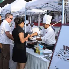 Service with a smile is our guarantee. Here is one of our professional chefs serving a freshly prepared pasta dish at a VIP lounge event at the Mahalaxmi Racecourse. We ensure your guests feel welcomed and well-cared for.