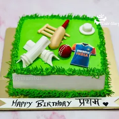 A perfect cake for any cricket lover. This square cake looks like a cricket pitch, complete with a fondant bat, ball, stumps, and an Indian team jersey.
