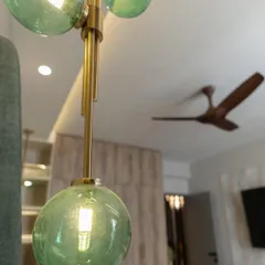 Another angle of the green glass pendant, showing how it contrasts beautifully with the warm wood tones of the fan and wardrobe in the background.