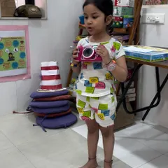 A young student participating in our "Share and Shine" session. She brought her toy camera to talk about something she loves, giving her a comfortable way to practice speaking to a group.