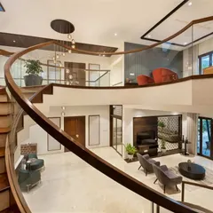We believe a staircase should be more than just functional; it should be a centerpiece. This custom-designed curved wooden staircase flows through a double-height space, connecting levels while creating a stunning visual statement of modern luxury.