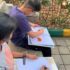 We often take our sketchbooks outdoors. Here, students are practicing observational sketching in a local park, learning to capture the forms and textures of nature directly from life.