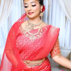 This pose captures the elegance of the South Indian bride. The soft makeup, combined with the rich red saree and gold jewellery, creates a look of pure grace.