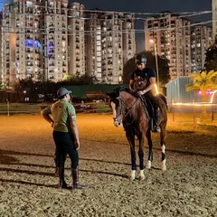 An instructor provides one-on-one coaching to a rider during a night lesson. The focused environment is ideal for skill development.