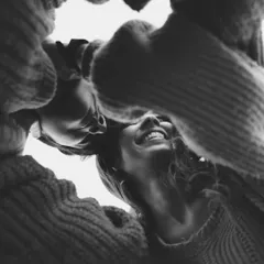 A joyful, creative portrait taken from a low angle. This perspective adds a unique and personal feel to the photograph, capturing a moment of shared happiness during a relaxed couple's session.