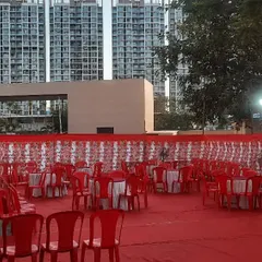 A large outdoor space set up with a pandal, red carpet, and seating. This shows how I can transform an open ground into a venue for hundreds of guests.