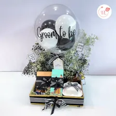 Spoil the groom-to-be with this exclusive hamper. It features a "Groom to be" balloon, gourmet snacks, and mini liquor bottles, all in a sophisticated black and white theme.