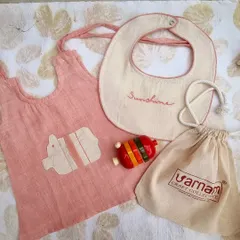 This adorable newborn set includes a pink handloom Kora cotton top with an elephant applique, a bib, and a colorful Channapatna rattle. The apparel is hand-dyed with natural plant-based dyes like manjistha, making it gentle on a baby's skin.