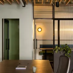 Transparency was a key theme for this finance company. This view from the main work area looks through fluted glass partitions into a breakout space, illustrating how we create visual connection between different areas while still providing a degree of privacy.