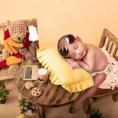Even the tiniest clients need a coffee break. This humorous and creative newborn setup features a miniature desk, laptop, and coffee, perfect for parents who love a bit of fun.