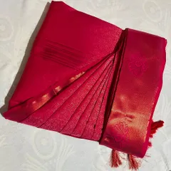 A close-up of a bright red silk saree with its pleats perfectly set. Notice the crisp folds and the neat fall, ready to create an elegant look instantly.