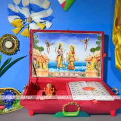 This Ram and Sita themed wedding gift box is a work of devotional art. The plush red velvet case opens to reveal a three-dimensional temple art scene, a space for your invitation, and a small Ganesha idol, blending spirituality with luxury.