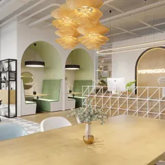 This view shows the reception area flowing into collaborative zones, including booth seating set within architectural arches. The design encourages interaction from the moment someone walks in.