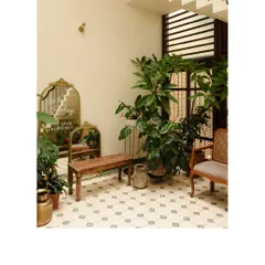 This corner of the courtyard at Casa 503 is filled with lush plants and vintage-inspired furniture. The patterned floor tiles and natural light make it a perfect spot to unwind.