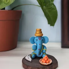 A small idol, a big presence. This little blue clay Ganesha, with his mushak and a plate of laddoos, is perfect for a quiet pooja corner or work desk.