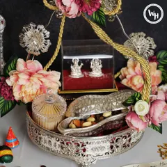 A truly sparkling Diwali gift. This silver-plated tray hamper includes beautiful silver Laxmi-Ganesh idols, a crystal jar for sweets, and assorted dry fruits, all decorated with fresh flowers.