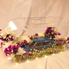 We curated this stunning gift hamper featuring a Mercedes-Benz toy car, surrounded by fresh flowers and fairy lights in a clear acrylic box. It's all about creating that wow factor.