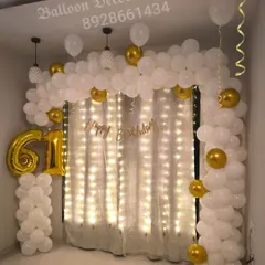 A duplicate view of the classy 61st birthday decoration, showcasing the beautiful combination of white and gold balloons with warm lighting.