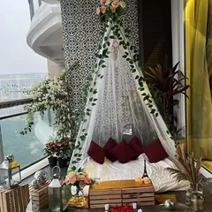 The same romantic proposal cabana seen during the day, showcasing the floral details, lanterns, and elegant decor against the daytime city view.