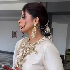 A side profile of the client wearing the embellished braid. The front is styled with a soft, face-framing wave, balancing the drama of the braid. This demonstrates how to create a complete, balanced look.