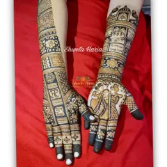 A full view of the personalized bridal mehendi, showing how the story flows from the palms up the arms, complete with intricate patterns and meaningful figures.