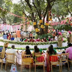 A wide shot of a beautiful outdoor Pangat setup under a large tree. This traditional community-style dining is a wonderful way to bring guests together for a shared cultural experience.