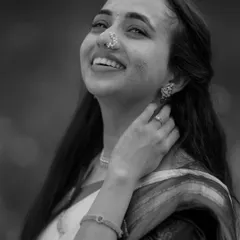 A timeless black and white portrait of a bride during her Haldi, her joyful expression and the smear of turmeric on her cheek telling a beautiful story.
